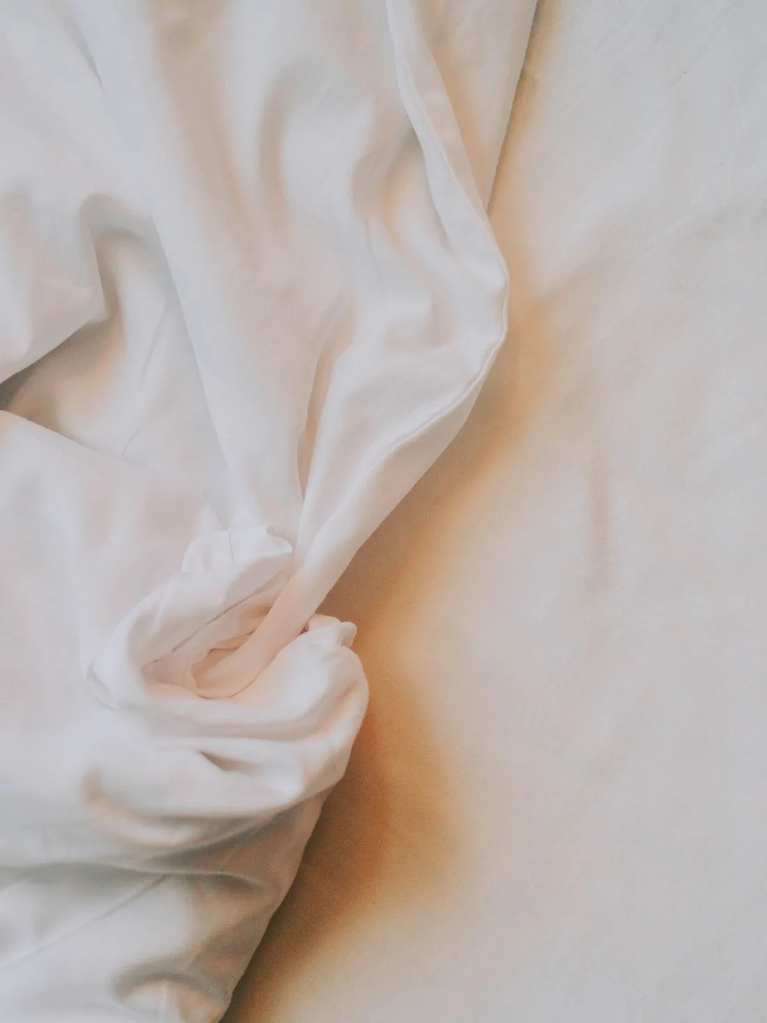 Soft folds of cream linen in warm natural light